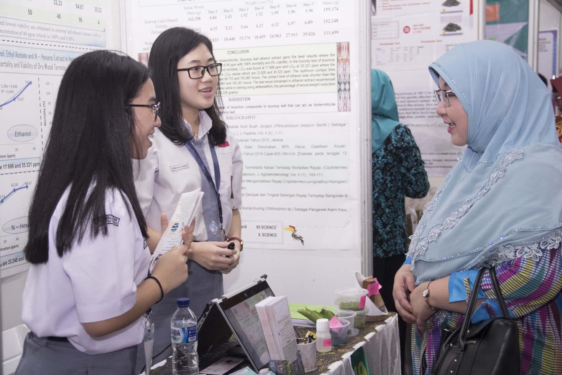Students presenting their research project to a judge at the ISPO exhibition