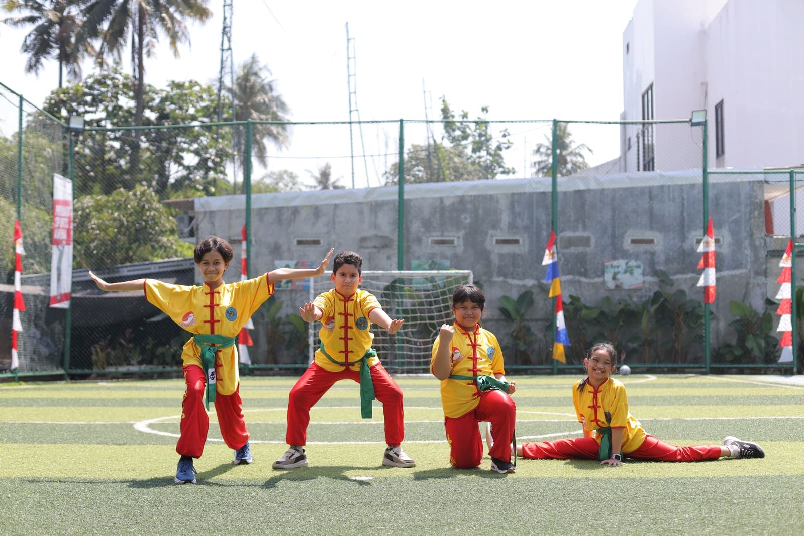 Students in wushu uniforms posing on the sports field