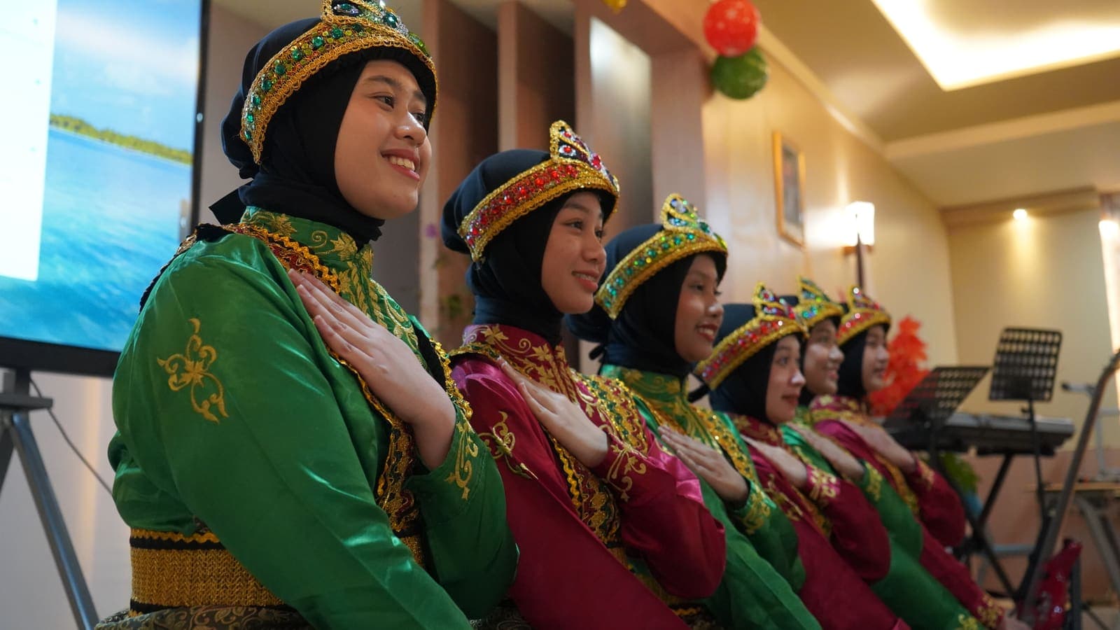Smiling dancers in traditional Acehnese costume before a performance