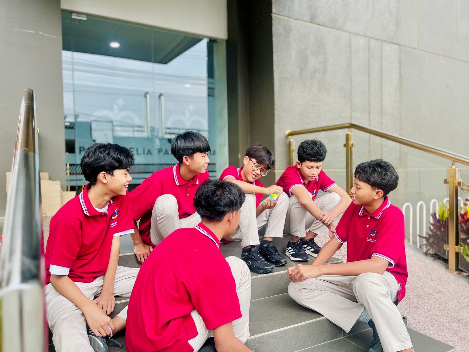 Students playing with a puzzle cube on the school steps